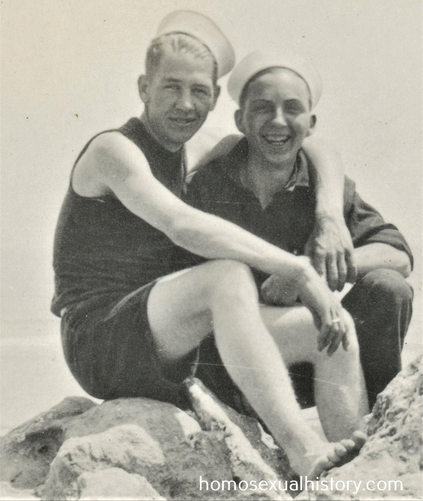 USA - Military. 1930s. Sailor couple on rocks by sea.